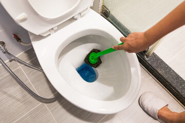Hand of woman in glove cleaning toilet bowl using brush, concept for house cleaning and Preventing Coronavirus COVID19