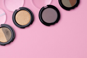 Set of eyeshadows make up products on pink
