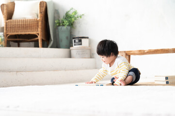 Naklejka premium 一人遊びをしていて上手に遊ぶ赤ちゃん 左側にコピースペースあり