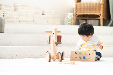 広い部屋でおもちゃで遊ぶ日本人の赤ちゃん　コピースペースあり 広角