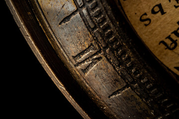 Old metal watch dial in dark macro photo