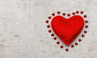 Holiday composition with a red plush heart on a concrete background. Top view, copy space. Valentine's day concept.