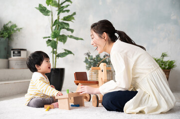 きれいな新築の様な広い部屋で美人なママと家族団らんの幸せな若いファミリー 下にコピースペースあり Wall Mural Kapinon