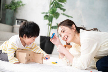 きれいな新築の様な広い部屋で美人なママと家族団らんの幸せな若いファミリー 下にコピースペースあり Wall Mural Kapinon