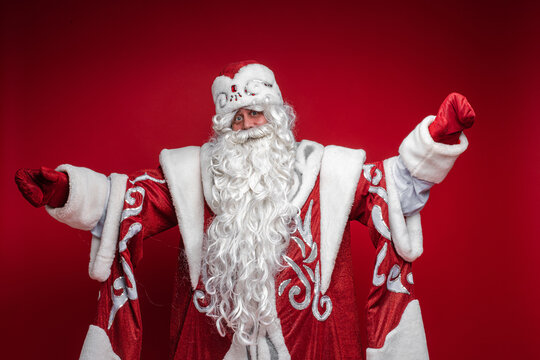 father frost with long white beard invites you to hug, picture isolated on red background
