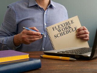 Man shows Flexible work schedule and offers a pen for filling.