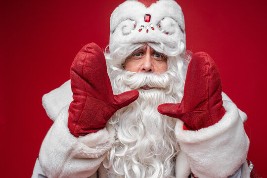 santa claus with long white beard calls someone, picture isolated on red background