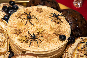 A spooky halloween cake with plastic spiders on the top