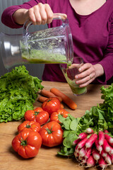 Vegan woman making vegetable juice for detox