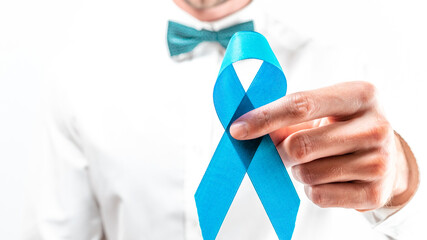 Cancer men. Awareness prostate of health in November. Hipster men in bright shirt, cyan bowtie with blue ribbon in hands on white background. Supporting people living and illness.