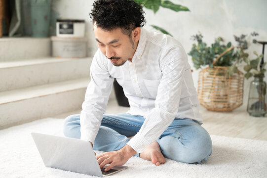 広い部屋でリモートワークの返事をチャットでするヒゲの管理職男性3　コピースペースあり