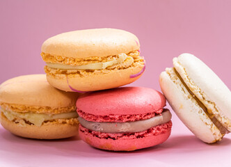 Colorful french cookies macarons set on pink background. Tasty fruit, almond sweet cookies, cake macaron