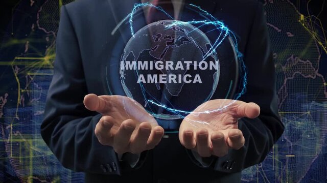 Male hands activate a conceptual holographic text Immigration America. Businessman in a suit with a hologram of planet Earth on a background of a futuristic wireframe city