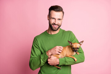 Obraz premium Photo portrait of happy cheerful man keeping small best friend brown dog isolated pastel pink color background