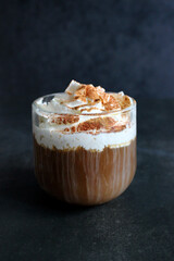 Cappuccino with cinnamon. A glass of fresh cappuccino on the table. vertical photo