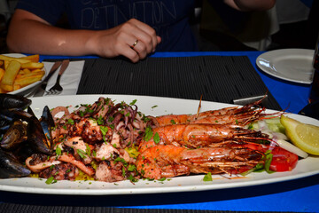 Delicious seafood platter from Malta  - freshly caught and grilled octopus tentacles, calamari rings in tempura, giant shrimps, clams, fish fillets and mussels 