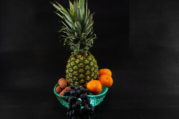 Still life with ripe fruit backlit on black background