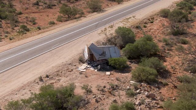 Aerial of camper caravan crashed on a highway accident in a desert rural area. Motorhome crashing event on the motorway. Travel and insurance concepts.