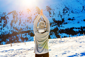 Woman practicing yoga in a landscape with snow in winter
