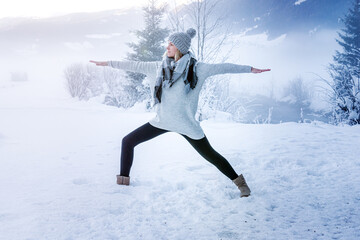 Woman practicing yoga in a landscape with snow in winter - 402290116