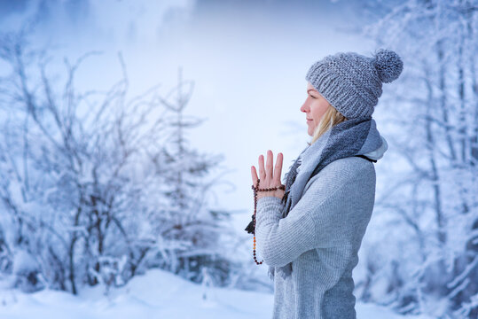 Woman practicing yoga in a landscape with snow in winter