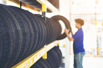 Retirement man touching and choosing for buying a tire in a supermarket mall. Measuring rubber car...