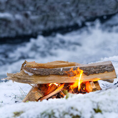 cozy fire on the river bank in winter. small warm bonfire in winter time. campfire by the river on snow an winter season