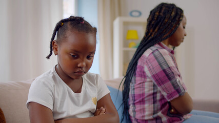Young african mother and small daughter avoid talking after misunderstanding