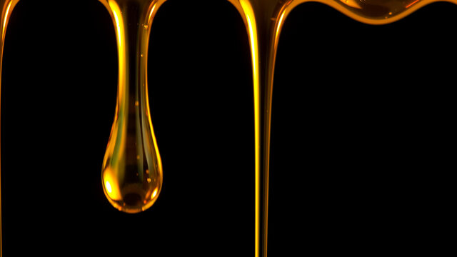 Pouring Oil Drop Isolated On Black Background. Macro Shot.