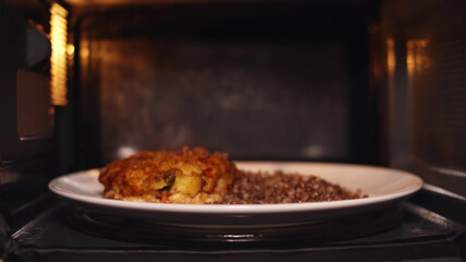 Plate with food spinning and warming in microwave oven