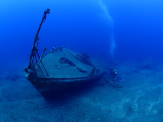 scuba divers exploring shipwreck scenery underwater ship wreck deep blue water ocean scenery of...