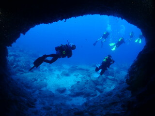 cave diving underwater scuba divers exploring caves and having fun ocean scenery sun beams and rays...
