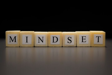 The word MINDSET written on wooden cubes isolated on a black background