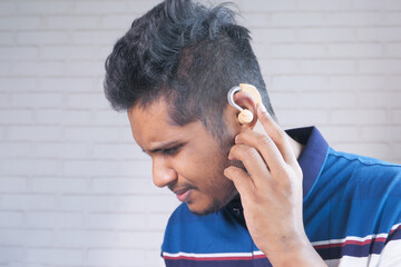 Hearing aid concept, a young man with hearing problems.