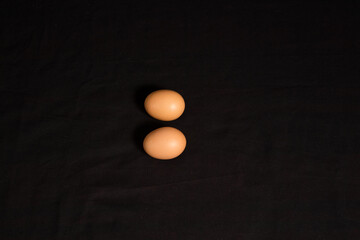 High angle shot and top view of two eggs isolated on black background. 