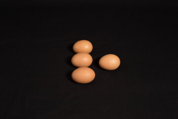 High angle shot and top view of four eggs isolated on black background. 