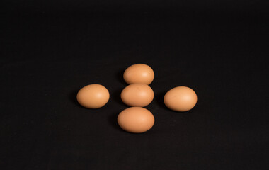 High angle shot and top view of five eggs isolated on black background. 