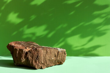 Natural stone podium display with leaf shadow. Product presentati on soft green background....