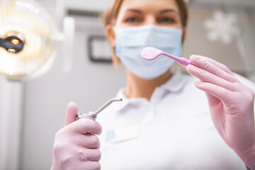 Selective focus on dental tools in the hands of female dentist