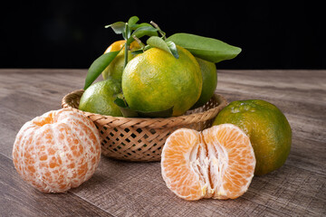 Fresh green tangerine mandarin orange on dark wooden table background.