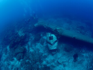 Obraz na płótnie Canvas scuba divers exploring airplane wreck underwater taking photos of c47 dakota airplane engine 