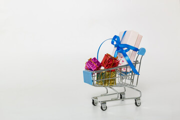 Gift box lie in a shopping trolley of new year festival, on white background,with copy space