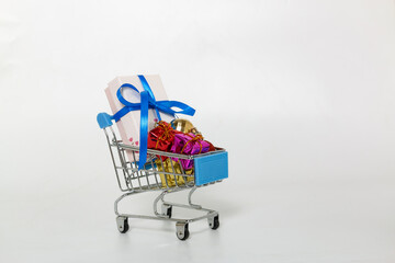 Gift box lie in a shopping trolley of new year festival, on white background,with copy space