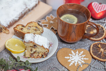 Christmas roll, tea with lemon in a wooden mug. New Year's tinsel. Celebratory still life.