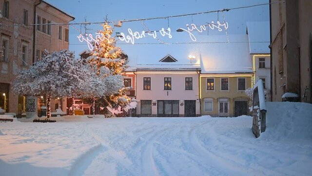Snowstorm in old medieval town Kranj, Slovenia. Snow falling on New Year&rsquo;s Eve. Snow covering street. White winter season. Static shot, real time, wide angle