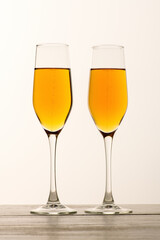 .Two glasses of champagne, wine with bubbles on gray background. Alcoholic drink: champagne, beer, white wine. New year and Christmas background. Valentine's Day. Vertical