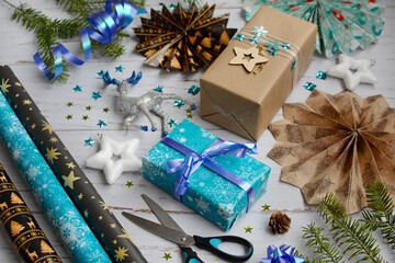 Close-up of blue and craft gift boxes and New Year's decor on a wooden light background.