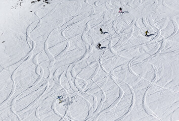 Snowboarders and skiers downhill on off-piste slope