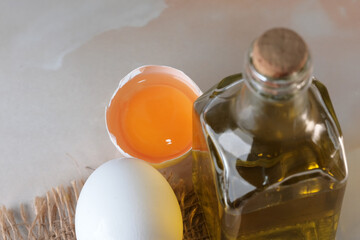 White raw eggs lie next to olive oil