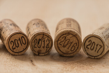 Wine corks on rustic wooden surface. Selective focus on year date.